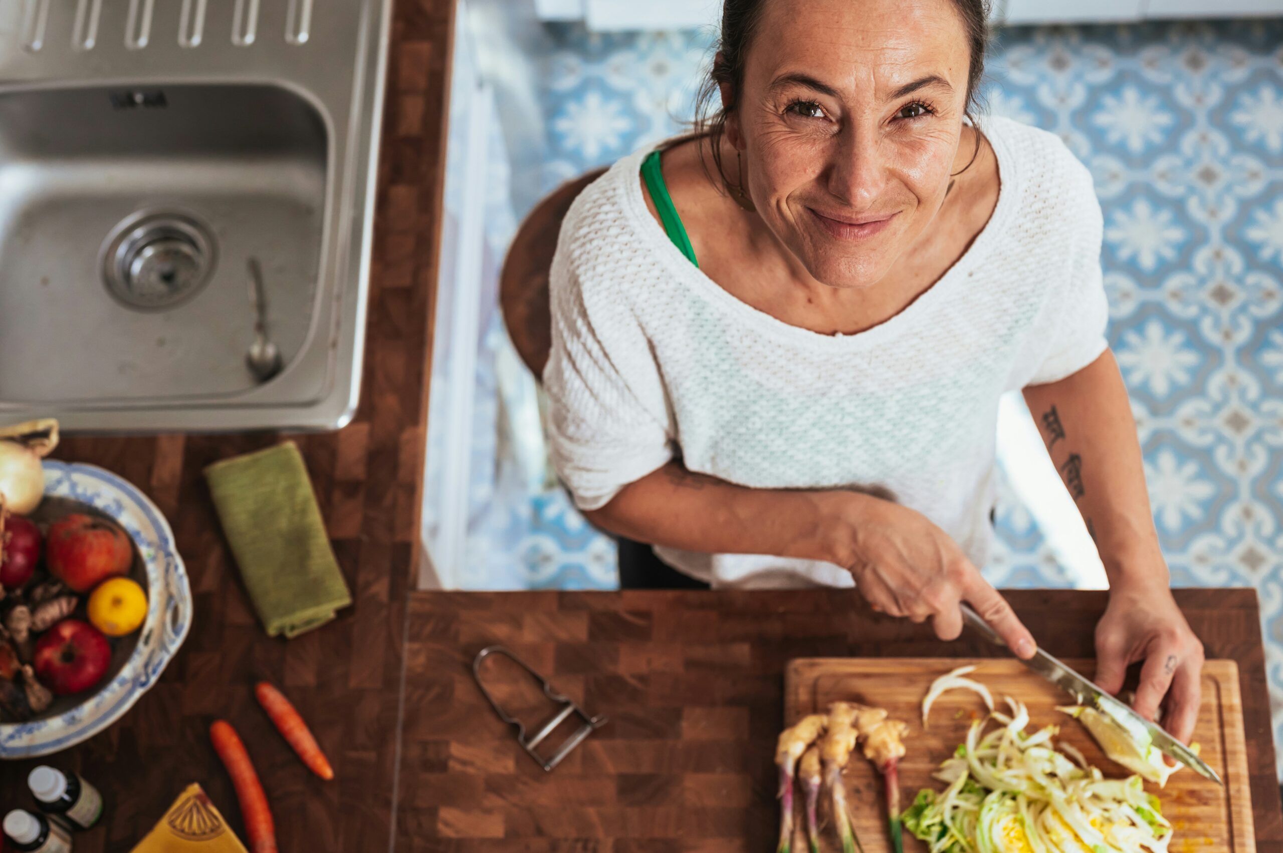 Elderly woman smiling in kitchen preparing food