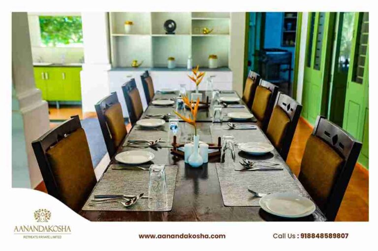 Ayurvedic dining hall setup with long wooden table at Anandakosha