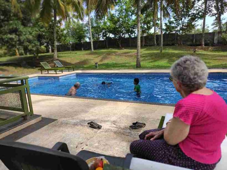 Guests relaxing near swimming pool at Anandakosha Ayurveda retreat