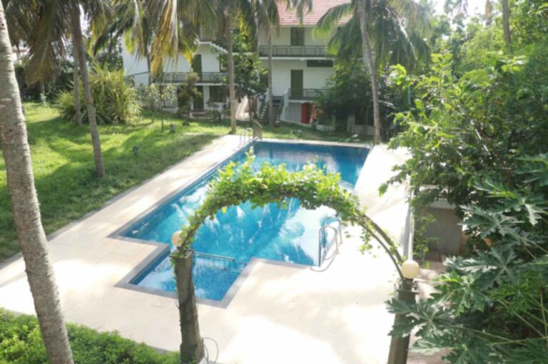 Aanandakosha swimming pool with clean water and greenery in afternoon